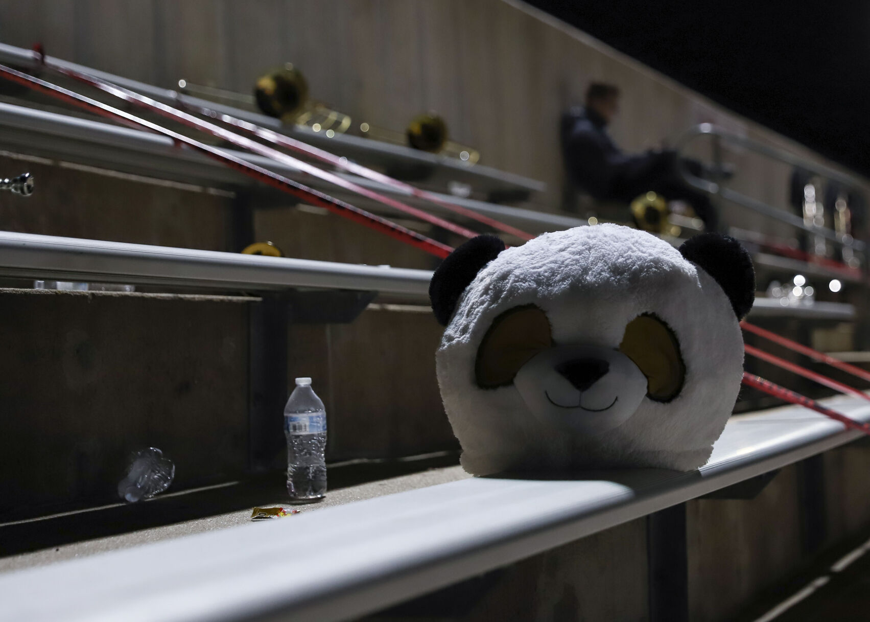 A costume panda head sits on empty bleachers